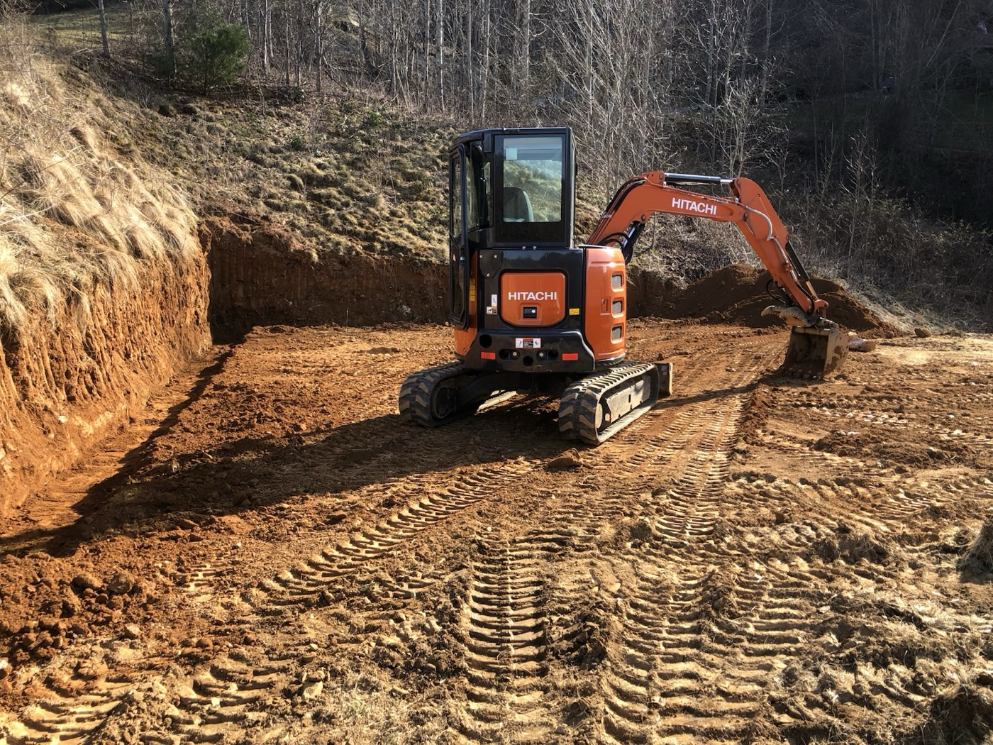 Excavator cutting a building pad into a hillside