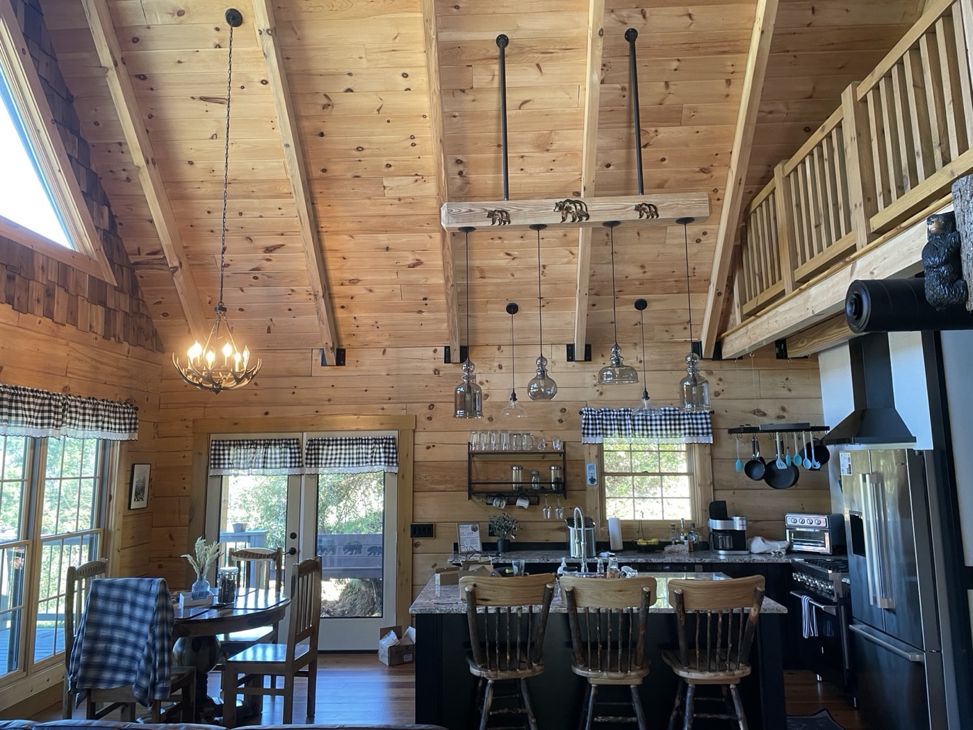 Vaulted pine great room with kitchen and loft railing