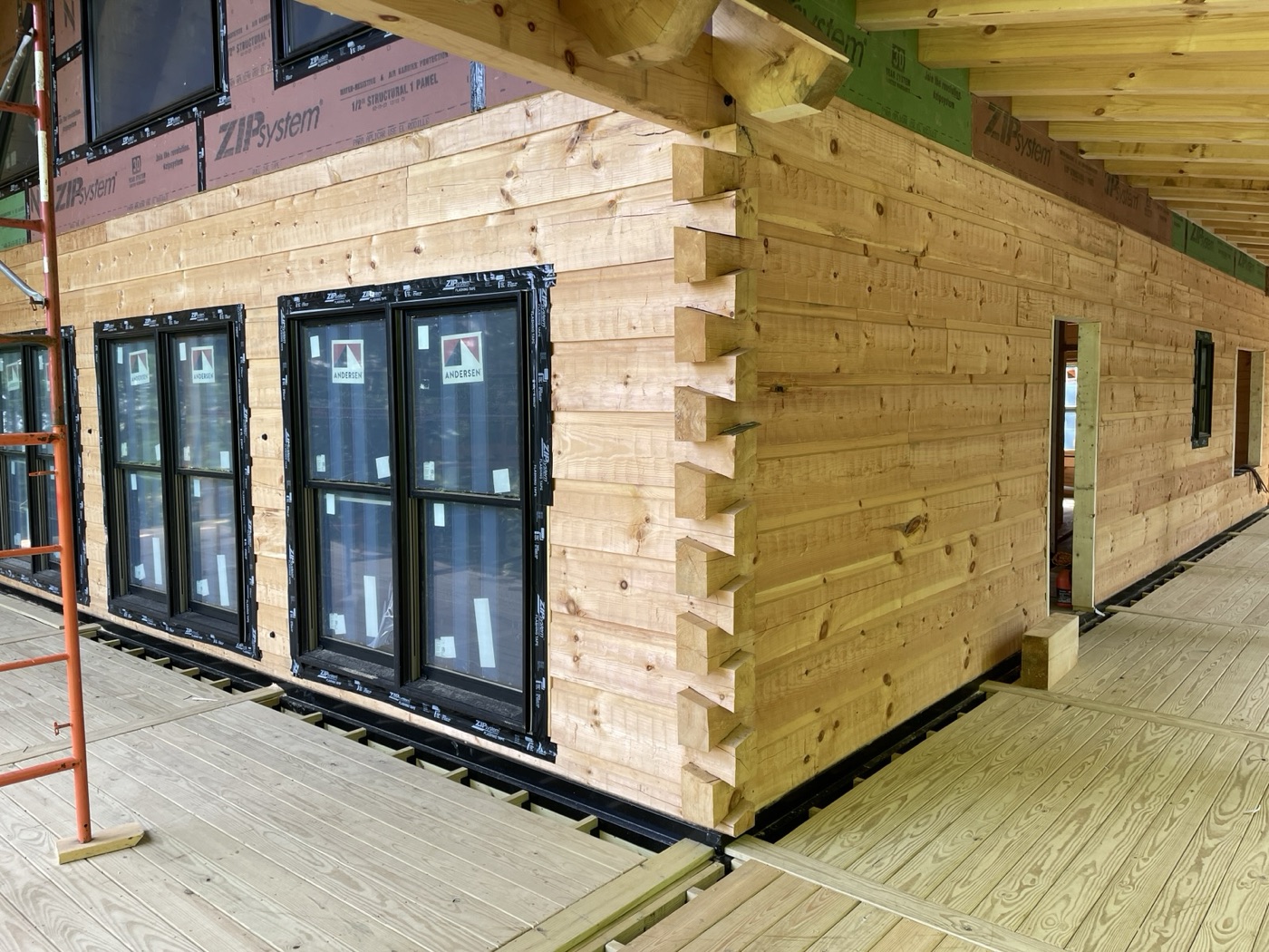 Corner joinery on a new log wall with black-framed windows
