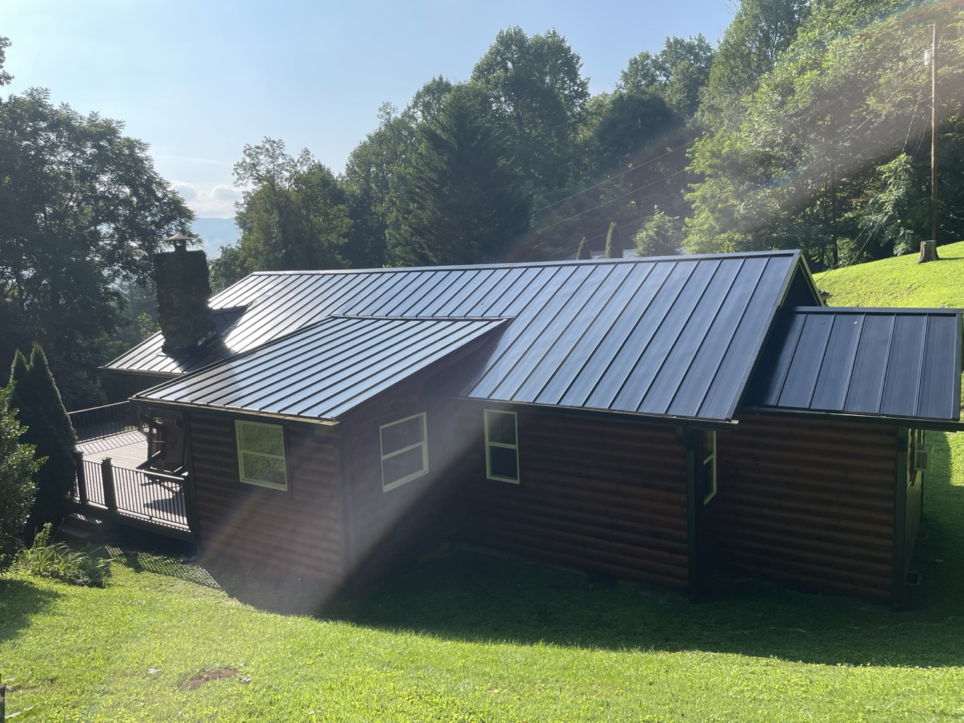 Dark standing-seam metal roof on a log-sided home